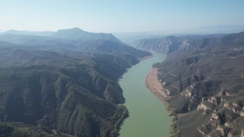 Aerial view of a winding river flowing through deep mountain canyons in China Video stock 342207863