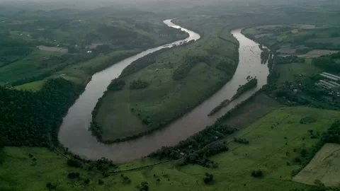 Aerial view of winding river at sunset amid green fields and forest. Stock Footage 233219852