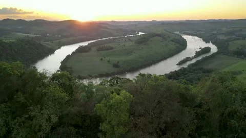Aerial view of winding river at sunset amid green fields and forest. Stock Footage 233219862