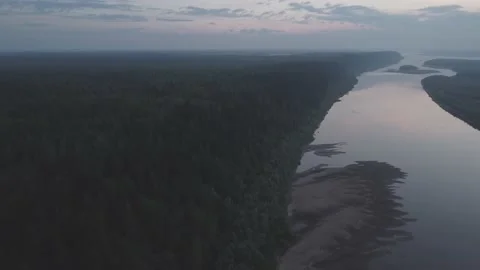 Aerial view of a winding river surrounded by dense forest at dusk. Stock Footage 227929429