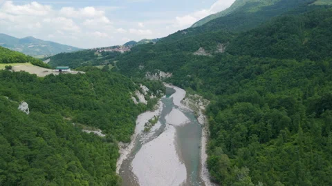 Aerial View of a Winding River Through Lush Green Mountains Video stock 277468724