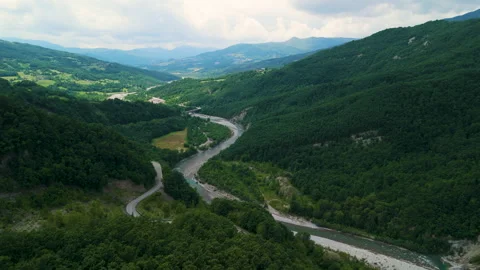 Aerial View of a Winding River Through Lush Green Mountains in Summer Video stock 277469208
