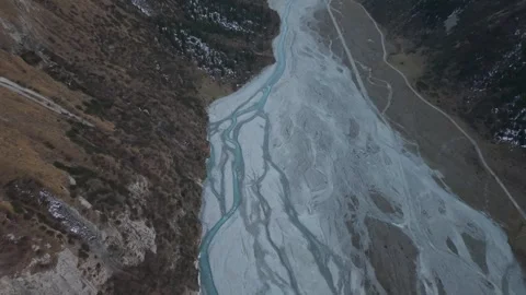 Aerial view of winding river through mountainous terrain at dusk Video stock 319559924