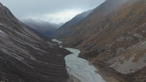 Aerial view of winding river through mountain valley with dynamic camera Stock Footage 321392482