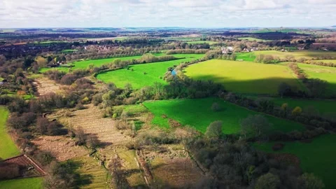 Aerial view of winding river through farmland and village in Wiltshire Vídeos de archivo 333893240