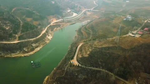 Aerial View of Winding River Through Hilly Landscape with Roads Vidéo 334855273
