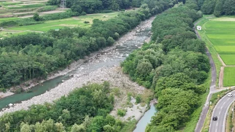 Aerial view of a winding river through lush green fields Stock Footage 340915828