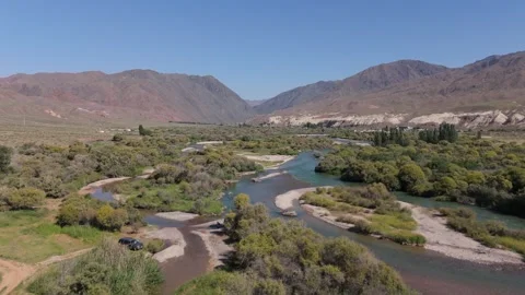 Aerial view of a winding river through green bushes and mountains, Kyrgyzstan Видео 347239820