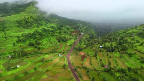 Aerial View of a Winding Road Between Lush Green Mountains in Maharashtra Видео 342701710
