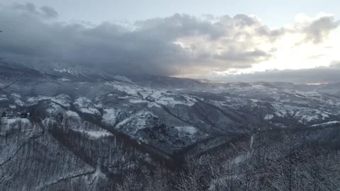 Aerial view of a winding road through a snowy forest. Stock Footage 310028371