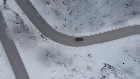 Aerial view of a winding road through a snowy forest. Stock Footage 310028413