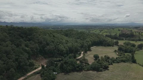 Aerial View of Winding Road Through Tropical Forest With City Plain and Mou.. Vídeos de archivo 337600739