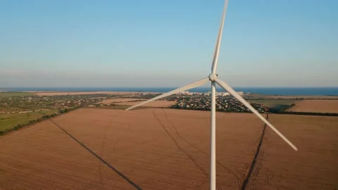 Aerial view of a windmill against the township and farmland at sunset. Stock Footage 159156232