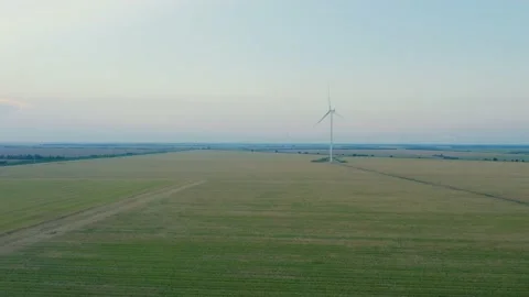 Aerial view of a windmill in agricultural fields generating renewable energy. Stock Footage 220763327