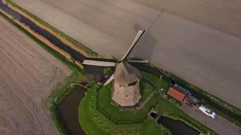 Aerial view of windmill blades rotating over flat fields, Holland Stock Footage 313362501