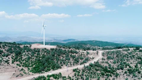 Aerial view of windmill generating electricity on mountain peak in forest area Stock Footage 229967541