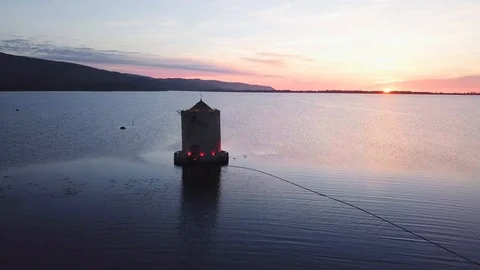 Aerial View A windmill on a sea lagoon at sunset Stock Footage 107847815