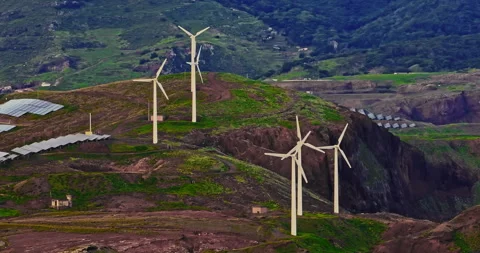 Aerial view of windmills standing on a cliff above the ocean in a picturesque Stock Footage 346628588