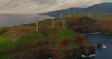 Aerial view of windmills, standing on a hill above the ocean at dawn, Canical Video stock 265197879