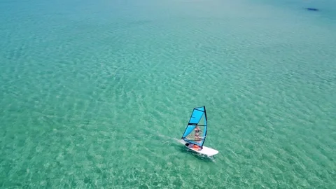 Aerial view of a windsurfer gliding over clear turquoise waters in Sithonia Stock Footage 280474199