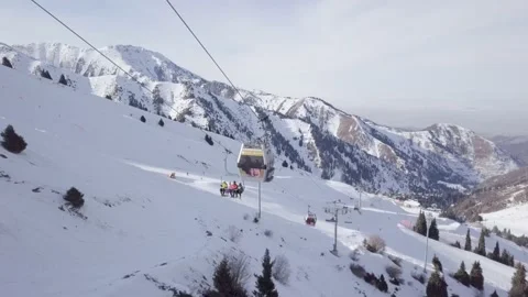 Aerial View. Winter Alpine Ski Resort Skiers on a ski lift and snow mountains Stock Footage 144045517