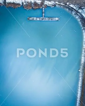 Aerial view of the winter lake with clear blue sea water and boat. Abstract pict Stock Photos
