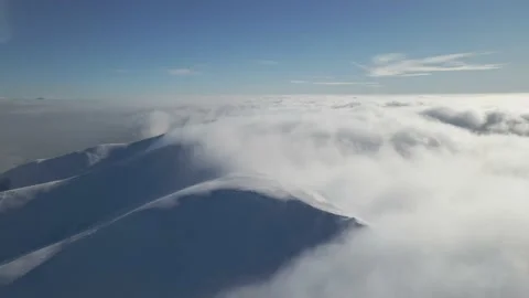 Aerial view of a winter mountain range half covered in fog on a sunny day. Snow Stock Footage 148300478