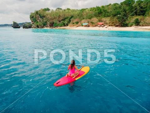 Aerial view of woman on stand up paddle board in blue ocean. Stock Photos