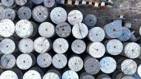 Aerial view of wooden cable spools arranged in a grid pattern on the ground Stock-Footage 332132192