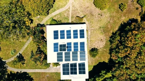 Aerial view of a worker cleaning solar panels on a rooftop, Honduras. 스톡 동영상 334173209