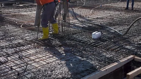 Aerial View: Workers and engineers pour concrete on a bustling site, creating a Stock Footage 296072627