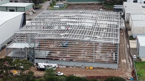 Aerial view of workers building warehouse steel frame structure Stock Footage 340381796