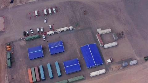 Aerial view of workers camp with blue roof buildings and containers in desert Stock Footage 317226955