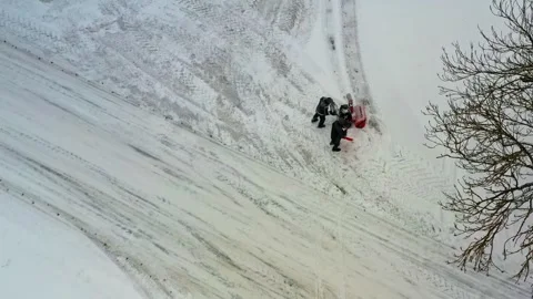 Aerial view of workers clearing snow from a road with a snowblower in winter Stock Footage 343733437