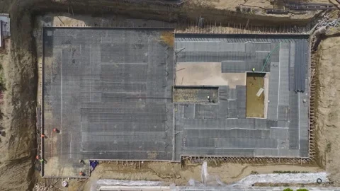 Aerial View: Workers install insulation and handle metal reinforcements under Vidéo 296096503