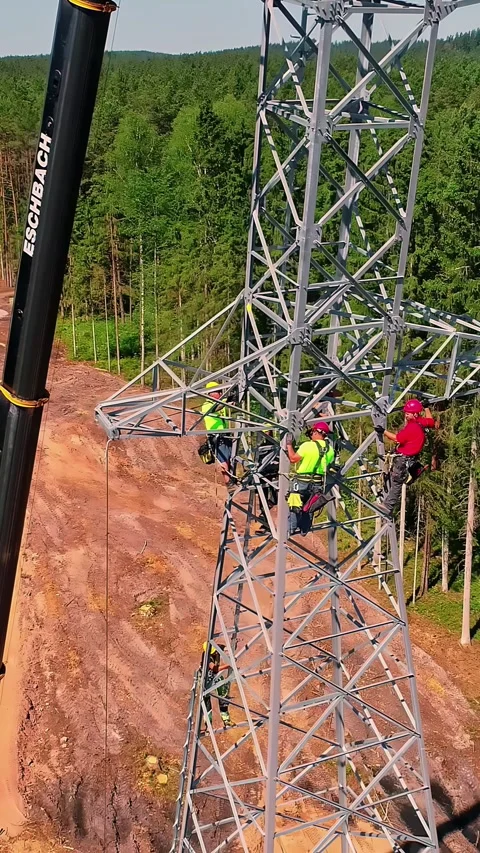 Aerial view of workers installing a high-voltage pylon, Latvia. Stock Footage 340636046