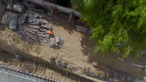 Aerial View: Workers insulate foundations and assemble metal structures under Stock Footage 296095961