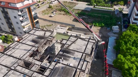 Aerial View: Workers load supplies and assemble metal frameworks on a busy Stock Footage 296174352