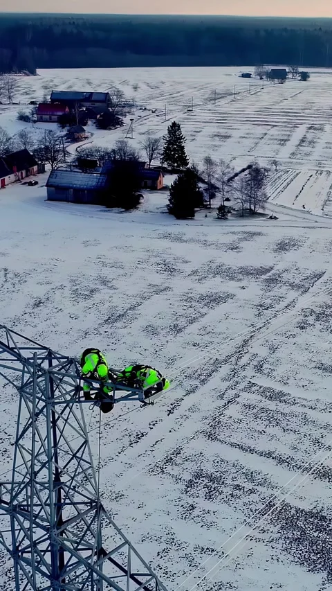 Aerial view of workers on a power line tower in winter, Latvia. Stock Footage 340635403