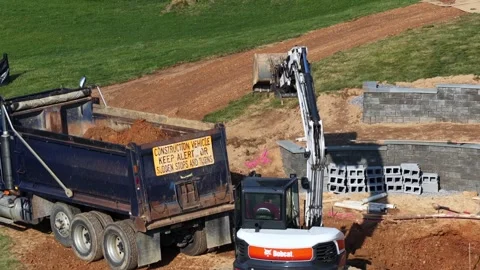 Aerial view of workers using an excavator for backyard pool construction at Stock Footage 333880646