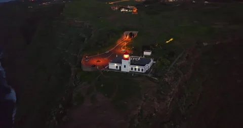 Aerial view to working lighthouse at dusk timelocated on a picturesque rock Video stock 266285525