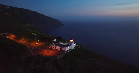 Aerial view to working lighthouse at dusk time located on a picturesque rock Stock Footage 267963689