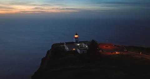 Aerial view to working lighthouse at dusk time located on a picturesque rock Stockbeeldmateriaal 271532227
