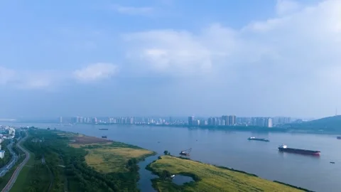 Aerial View of Yangtze River Flowing Past Urban Skyline and Green Riverbanks Stock Footage 342247536
