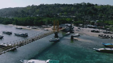Aerial view of the yellow bridge which connect between Nusa Ceningan and Nusa Stock Footage 250100208