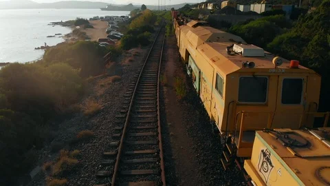 Aerial view of yellow cargo train beach  and track along the sea and the coastl Stock Footage 117738677