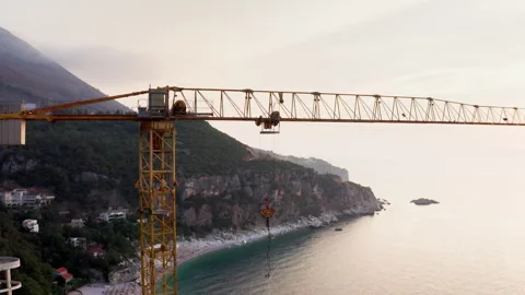 Aerial view of yellow construction crane over Perazica Do beach at sunset. Indus Stock Footage 340107961