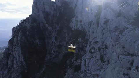 Aerial view of yellow elevator moving up on cable car near the high mountain Foto stock