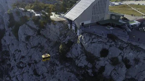 Aerial view of yellow elevator moving up on cable car near the high mountain Foto stock