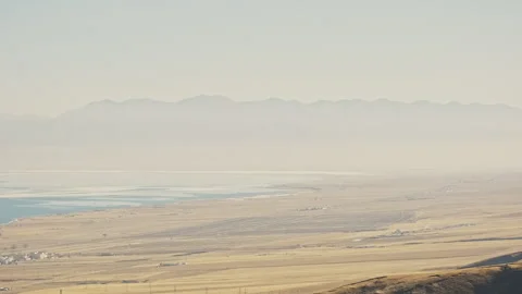 Aerial View of Yellow Grassland with Distant Mountains and Blue Ocean with Float 스톡 동영상 326446151